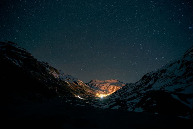 Bright illumination amidst mountains at night