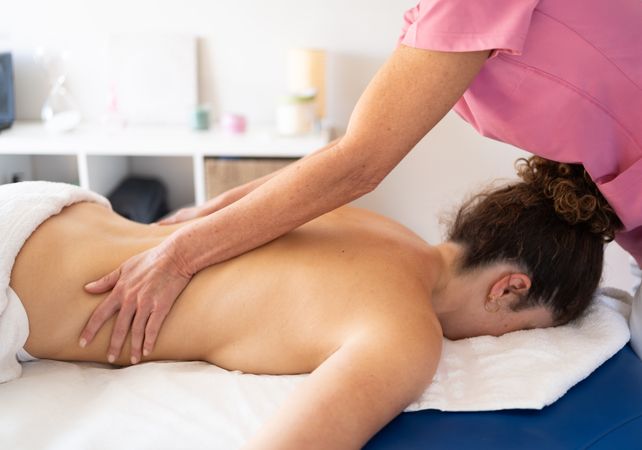 Masseuse massaging side of woman in spa salon