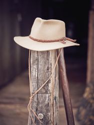 Cowboy hat on old wooden pillar