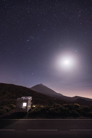 Traveling caravan in desert with bright moon
