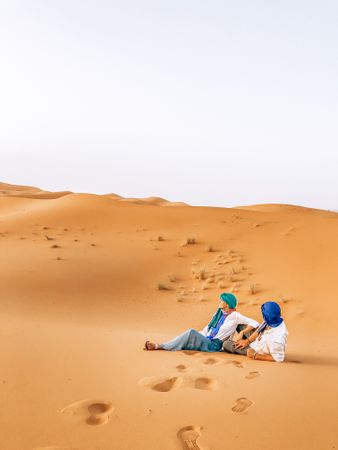 Couple sitting on desert sand