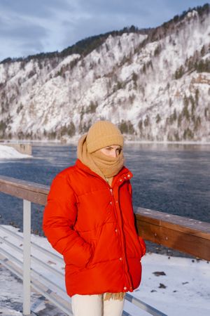 Woman enjoying landscape of river and snowy mountains