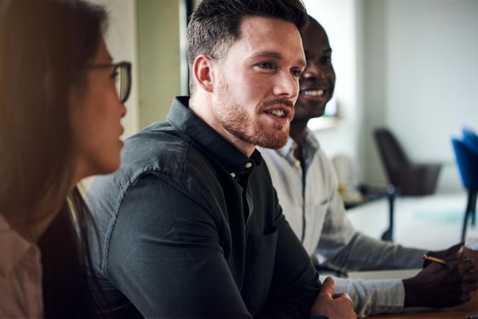 Man sharing ideas with multi-ethnic colleagues at work