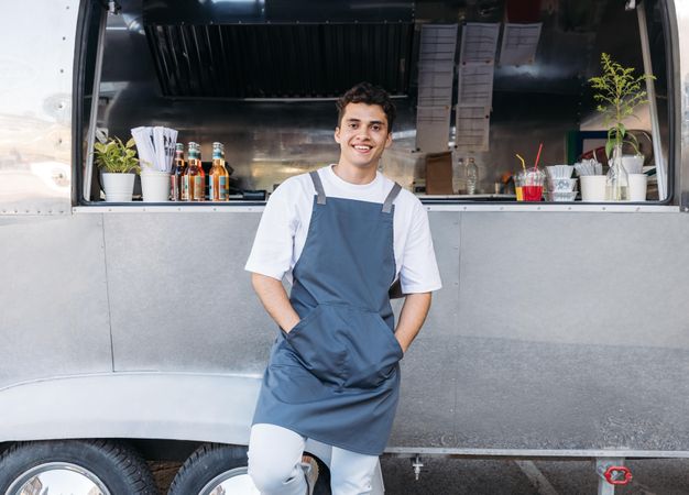 Smiling man in apron outside of food truck