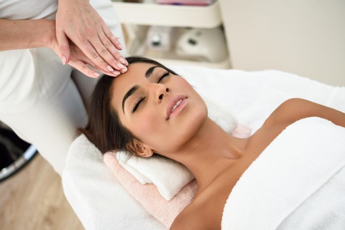 Woman receiving a facial treatment from a beautician