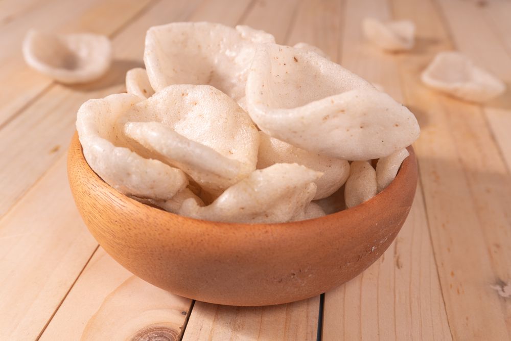 Crispy traditional crackers (kerupuk) served in a wooden bowl
