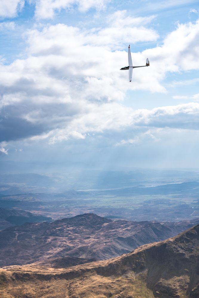 Small aircraft flying over mountains