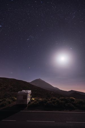 Traveling caravan in desert with bright moon