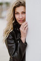 Charming tender woman standing behind white wall