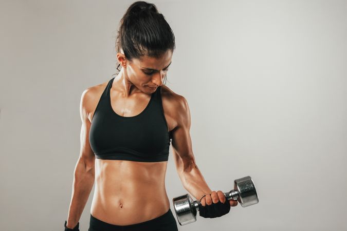 Attractive woman working out with dumbbells