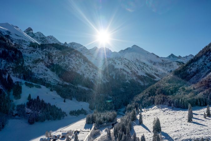 Winter sunny day in December, drone aerial view with snow covered pine forest and mountain peaks