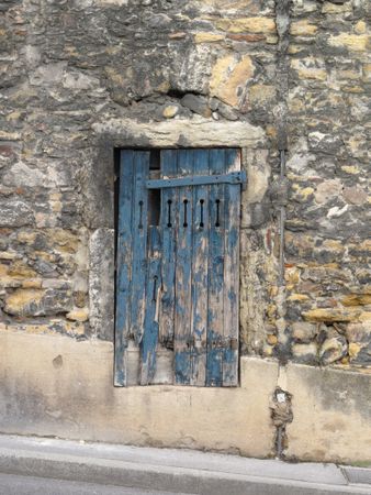 Blue painted wooden door on inclined street