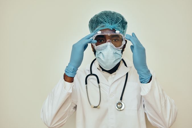 Male doctor adjusting protective eyewear during epidemic