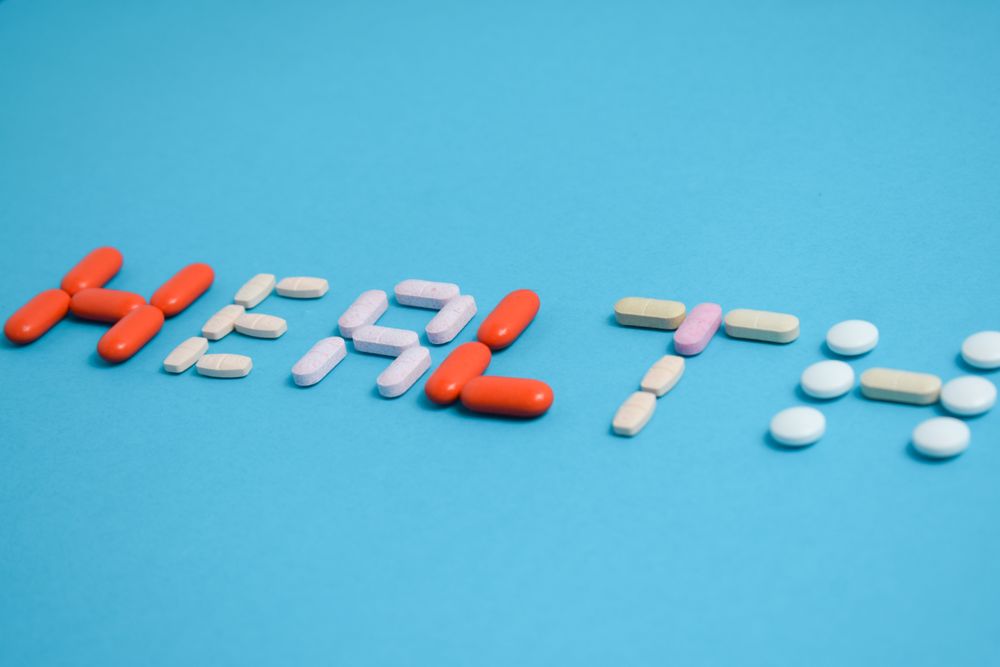 Various pills spelling the word "HEALTH" on blue background