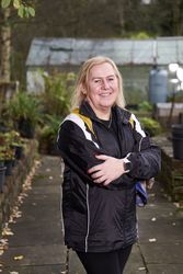 Woman standing outside green house