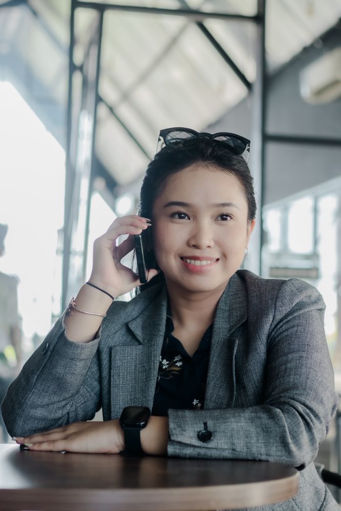 Cheerful businesswoman using smartphone during a break at cafe