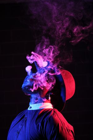 Man smoking in wig in neon light