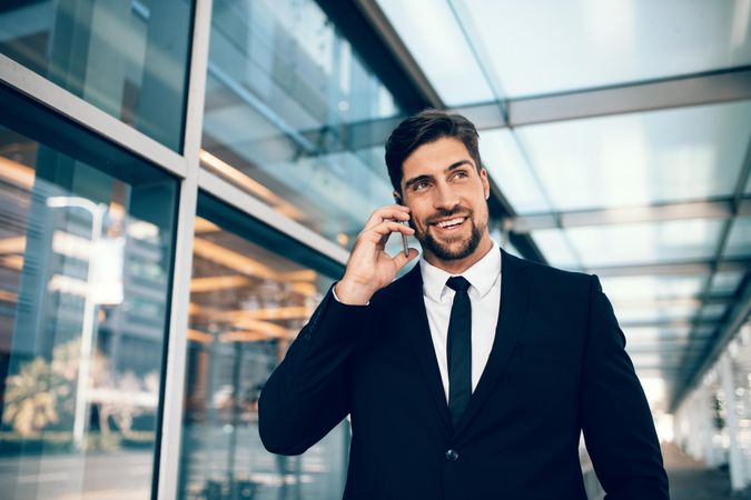 White businessman using mobile phone and smiling