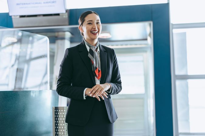 Friendly flight attendant standing at airport