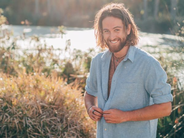Hipster man unbuttoning shirt to go swimming