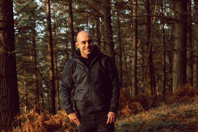 Smiling man standing in forest