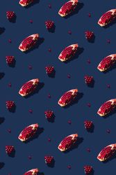 Pattern of pomegranate fruit slices on navy background