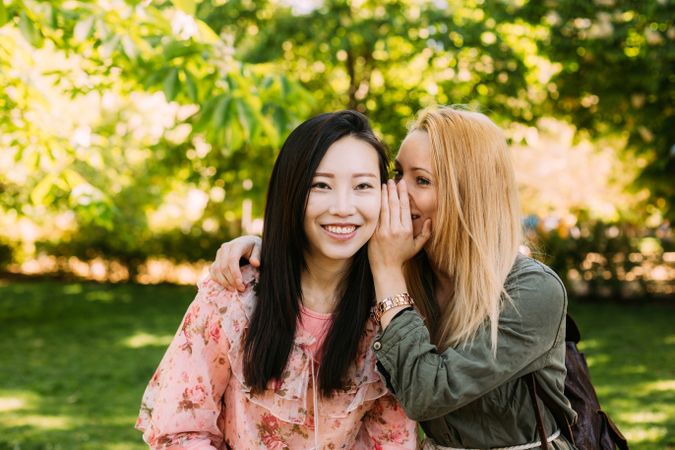 Multiracial female friends gossiping in park