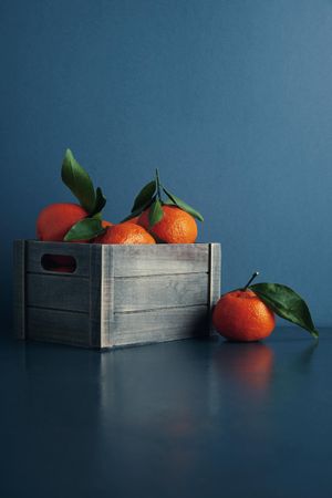 Crate of tangerines on blue background