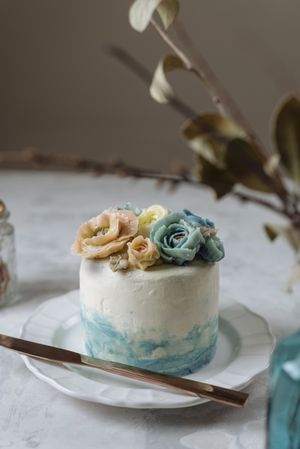 Buttercream flowers cake, blue and pastel peach colors