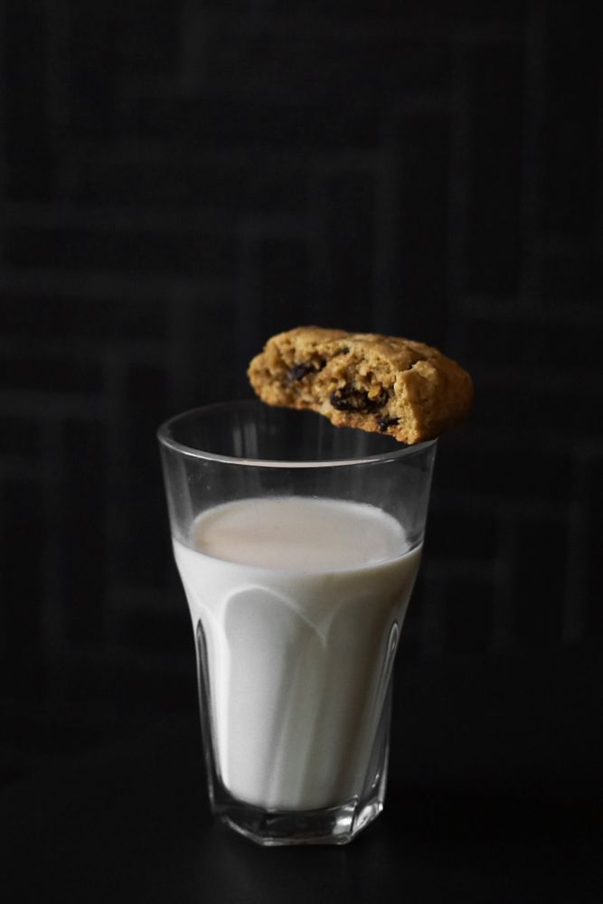 A glass of milk and raisin cookies