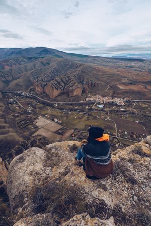Faceless woman resting on mountain top