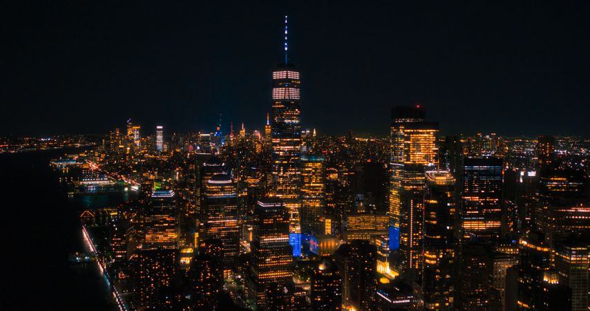 Night Aerial Photo with the One World Trade Center Skyscraper with Lights in Office Rooms Inside. Helicopter Flying Close to the Building with a View on New York City