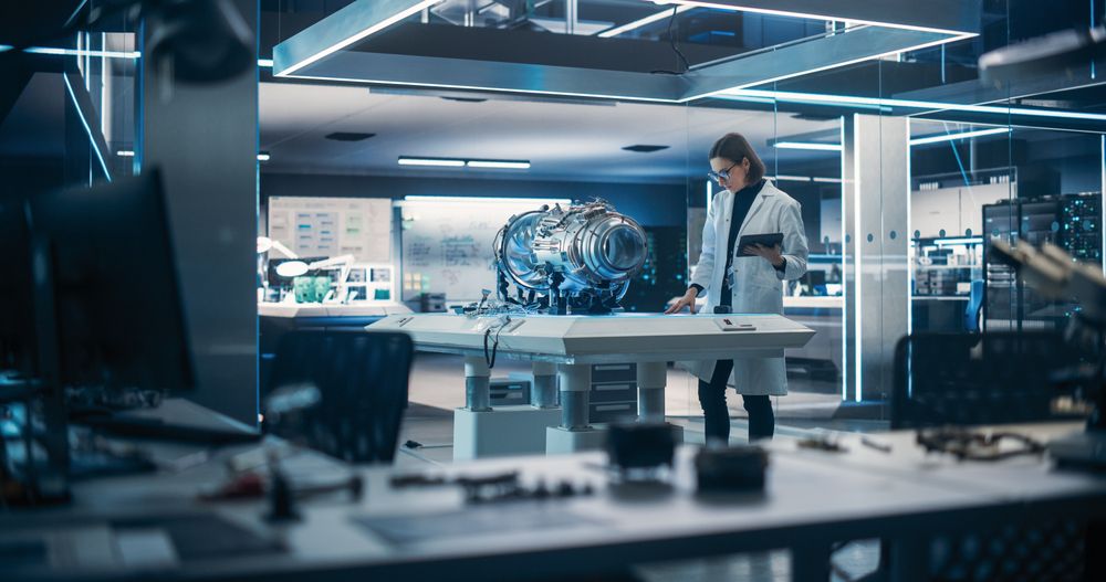 Propulsion Engine Researcher Working on Project with Futuristic Turbine Motor, Standing with Tablet Computer in Scientific Technology Lab.