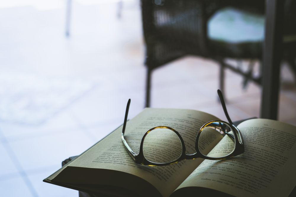 Framed eyeglasses on book page on a table