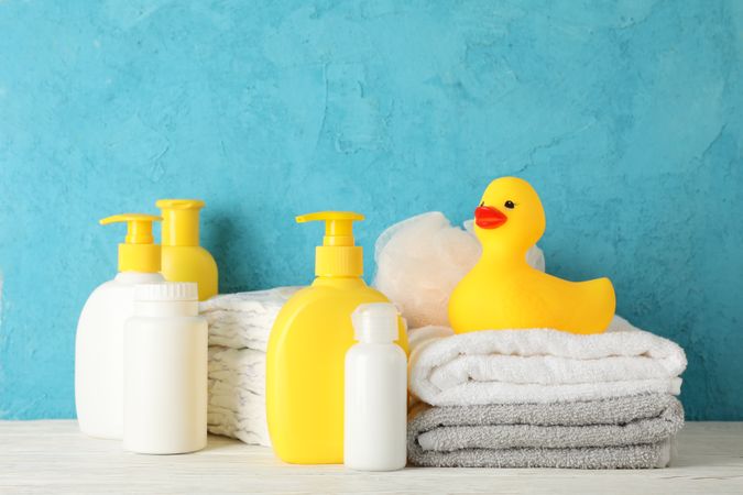 Baby hygiene accessories on wooden table against blue background