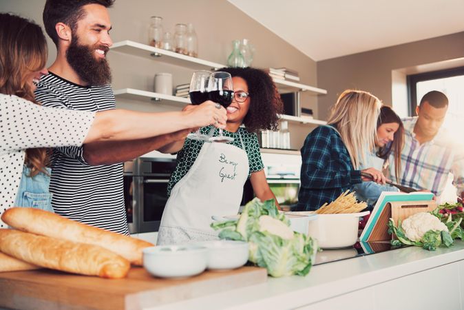 Friends toasting over a pot of boiling water with pasta