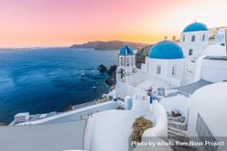 Calm sunset over Santorini with blue domes and town bEDr74