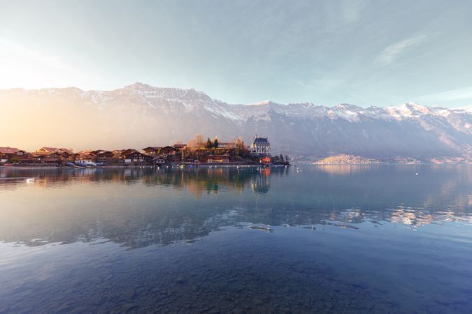 Tranquil lake with boats on pier against mountains