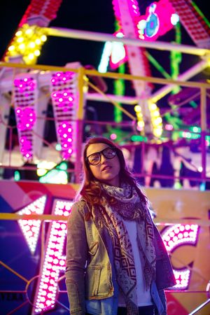 Stylish young woman near illumination on street