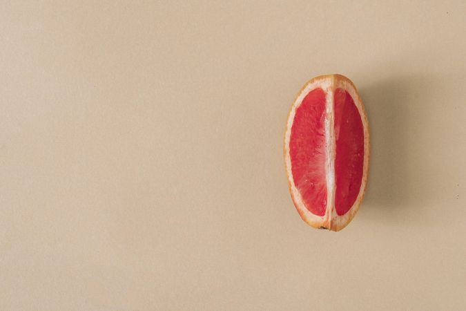 Minimal nature layout with grapefruit slice and pastel sand background