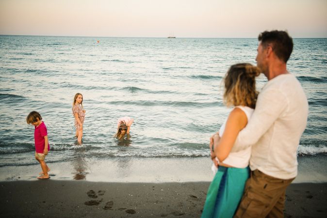 Parents with three kids on beach