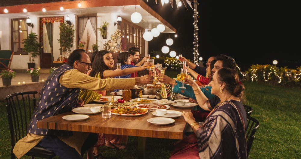 Big Family Celebrating Diwali: Indian Family in Traditional Clothes Gathered Together on a Dinner Table in a Backyard Garden
