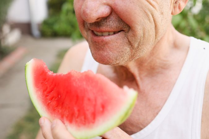 Happy Mature Man Eating a Fresh Watermelon.