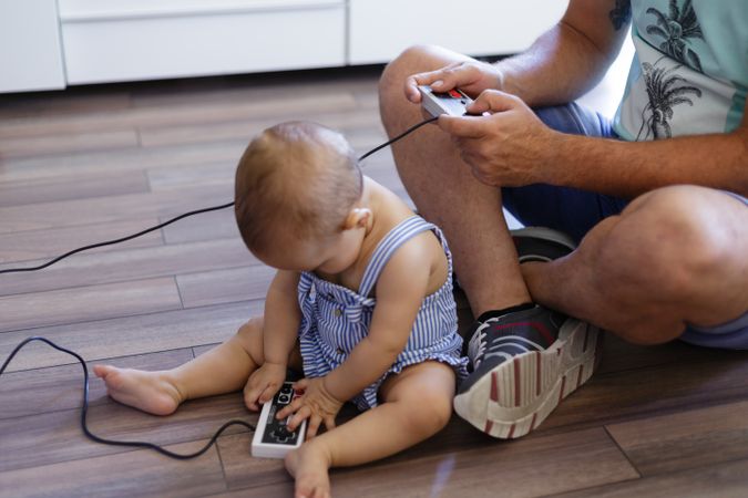 Anonymous father and baby playing video games