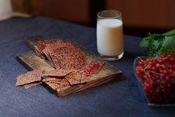 Vegan flaxseed bread with berries next to the glass with coconut