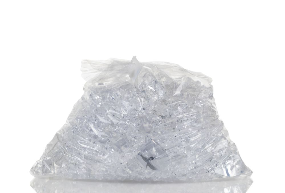Full plastic bag of crushed ice isolated on plain background with reflection