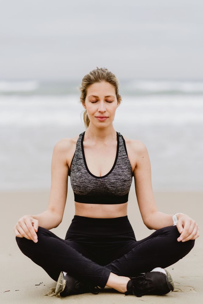 Woman meditating on the beach