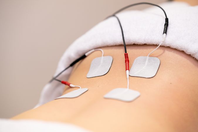 Electro pad therapy on lower back of woman