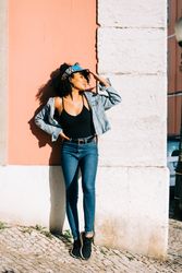 female leaning on wall and holding head