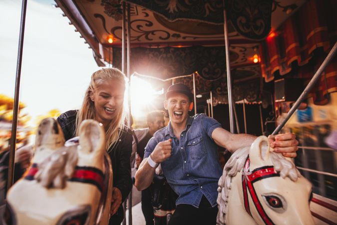 Shot of young couple having fun at an amusement park ride